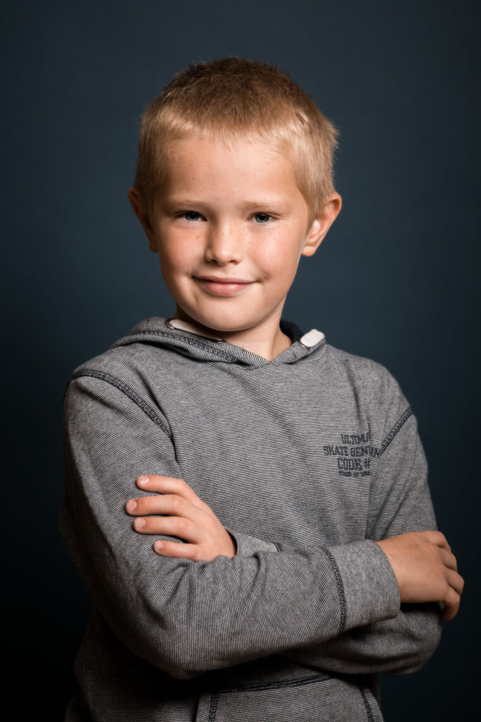 Junge vor blauem Hintergrund auf einem Schulfoto